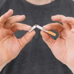 Zwei Hände zerbrechen eine Zigarette